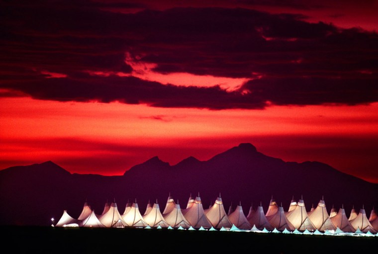The main terminal of Denver International Airport with sunset on the Rockies in the background Denver Colorado USA